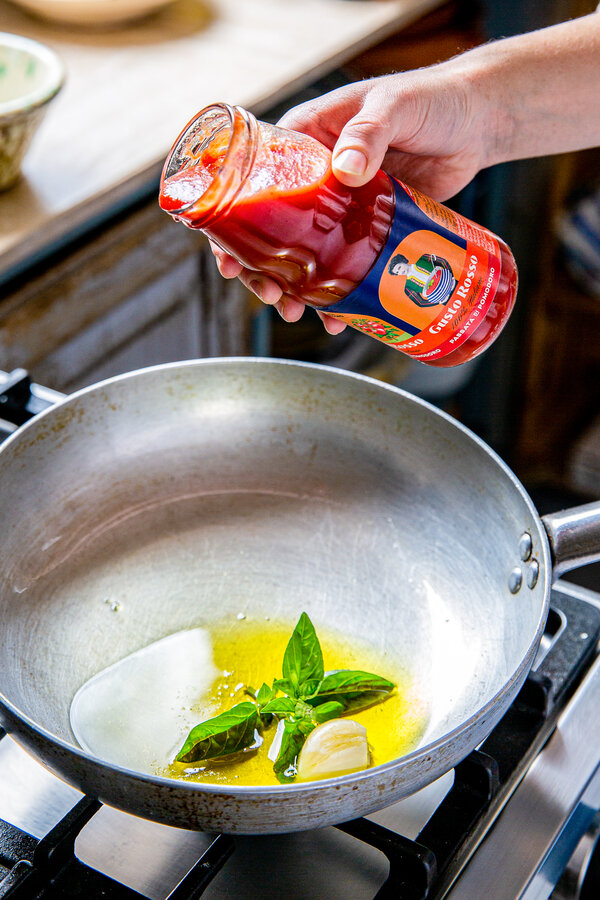 Voeg de olijfolie, knoflook en passata toe aan de pan